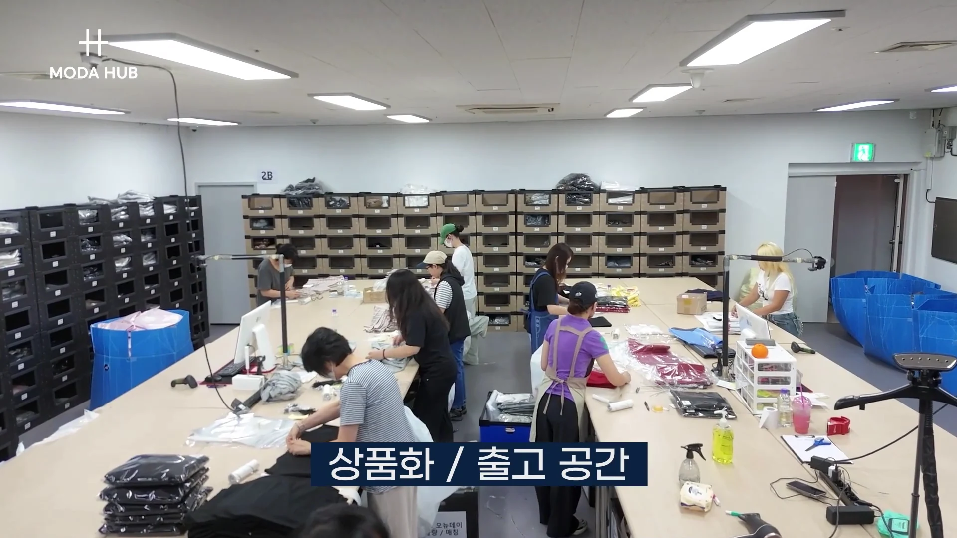 모다허브 1센터 상품화·출고 공간 — 작업대에서 검수와 포장이 진행되는 모습